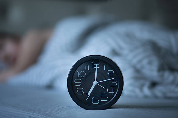 Morning sunlight through curtains next to an alarm clock